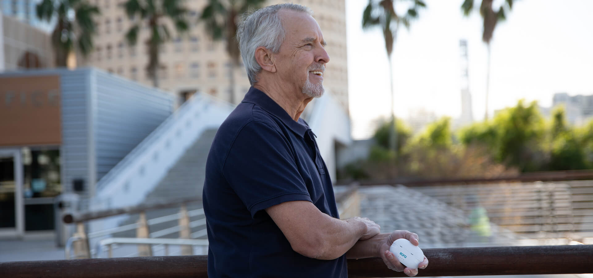 Person leaning on a railing holding the eara explore li+ in his hand