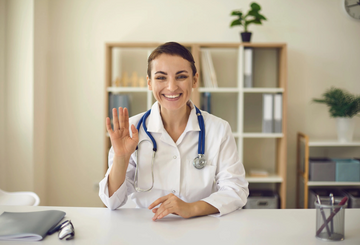 Audiologist at office waving