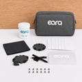 Eara product set including a gray case, white container, and various components on a white surface with a wooden background.