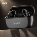 Graphite Eara Ascend Bluetooth Rechargeable RIC hearing aids  in their open charging case, with a small digital battery display on the front and the eara brand logo in the upper left.
