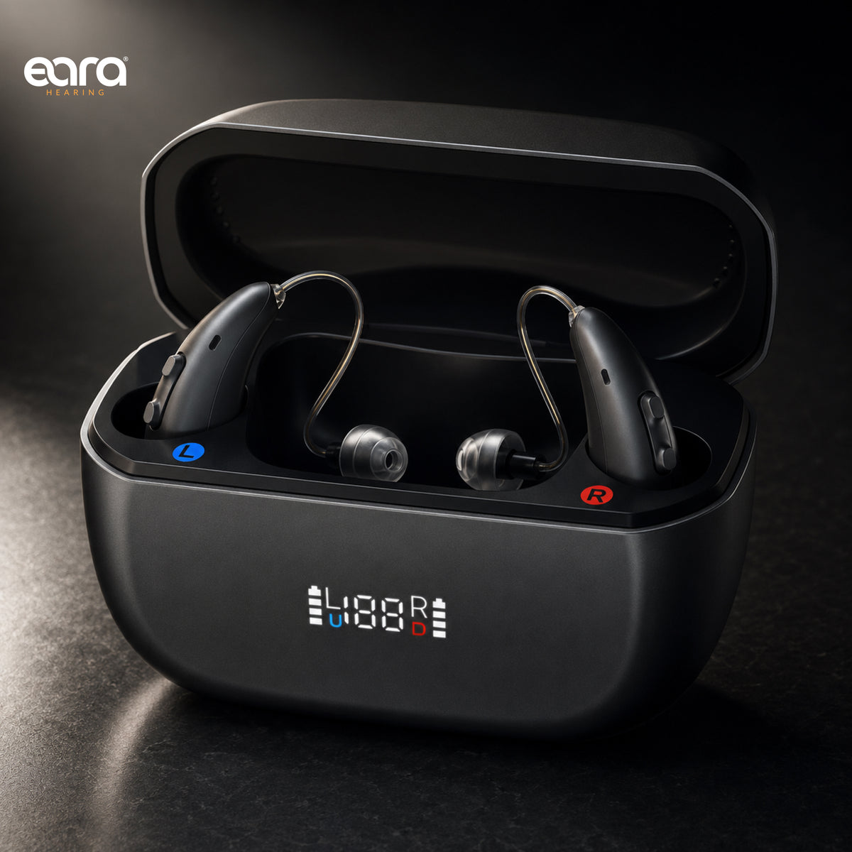 A pair of Eara Ascend Bluetooth rechargeable hearing aids, in a graphite charging case with an open lid, shown on a dark studio background. The case has a digital LED display showing and 'L R' markings, and the brand name 'eara' is visible in the top left corner.