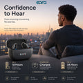 A promotional graphic for the Eara Ascend Bluetooth Rechargeable hearing aids, showing a man sitting by a window with a city skyline at sunset in the background, alongside an open black charging case containing the earbuds. Large text reads 'Confidence to Hear' and feature callouts mention up to 18 hours of use, 3 additional charges, and up to 54 hours total battery life.