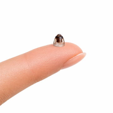 Eara 6mm open hearing aid dome shown on a fingertip for size comparison, compatible with Phonak, Oticon, Starkey, ReSound, Widex, Unitron, Jabra, Audien, Elehear, and HA FIT APP hearing aids for comfortable everyday hearing aid fit and airflow.